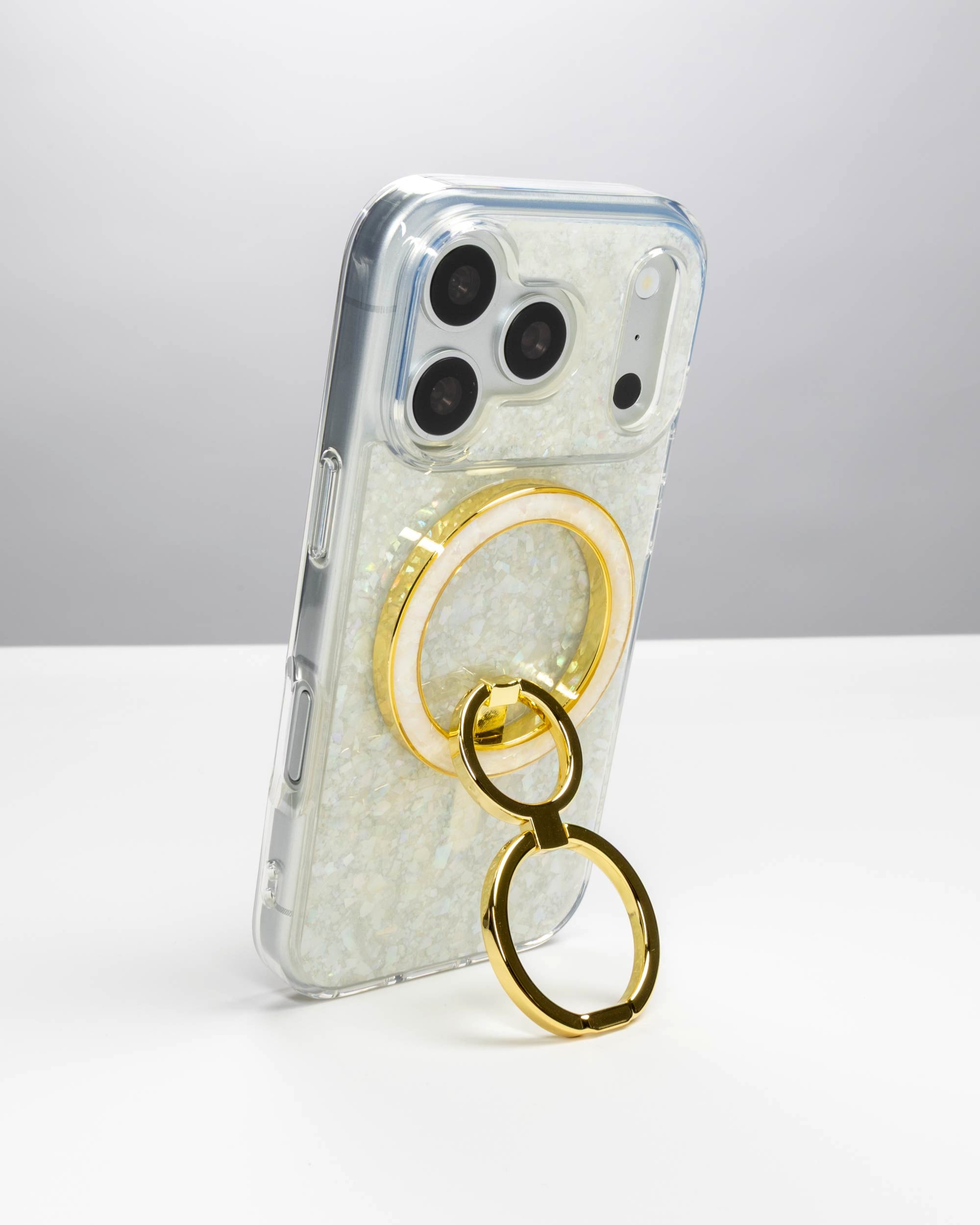 Snow Pearl Ring Stand, gold-tone, holding an iPhone upright as a stand
