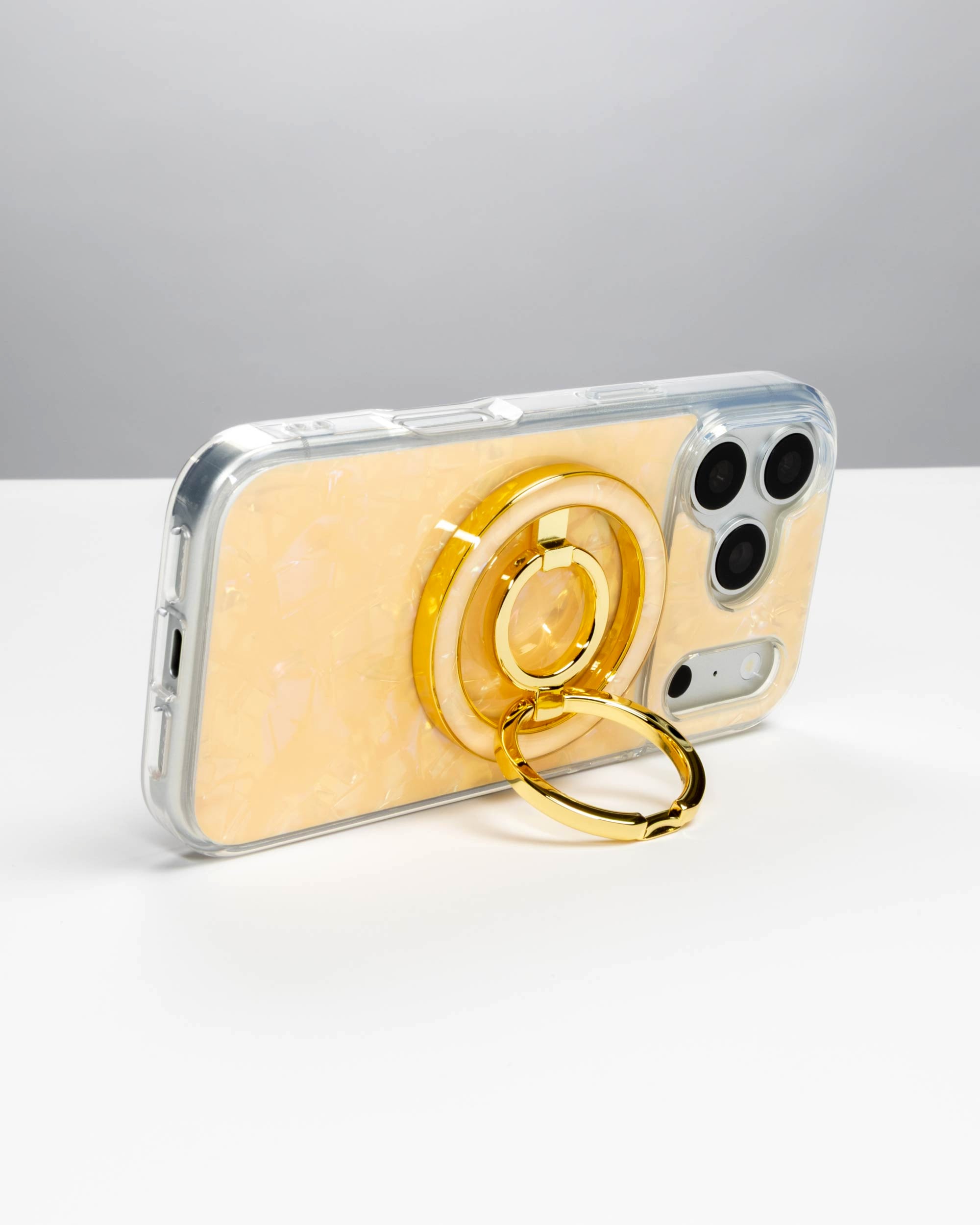 Apricot Shell Ring Stand, gold-tone, holding an iPhone in landscape as a stand