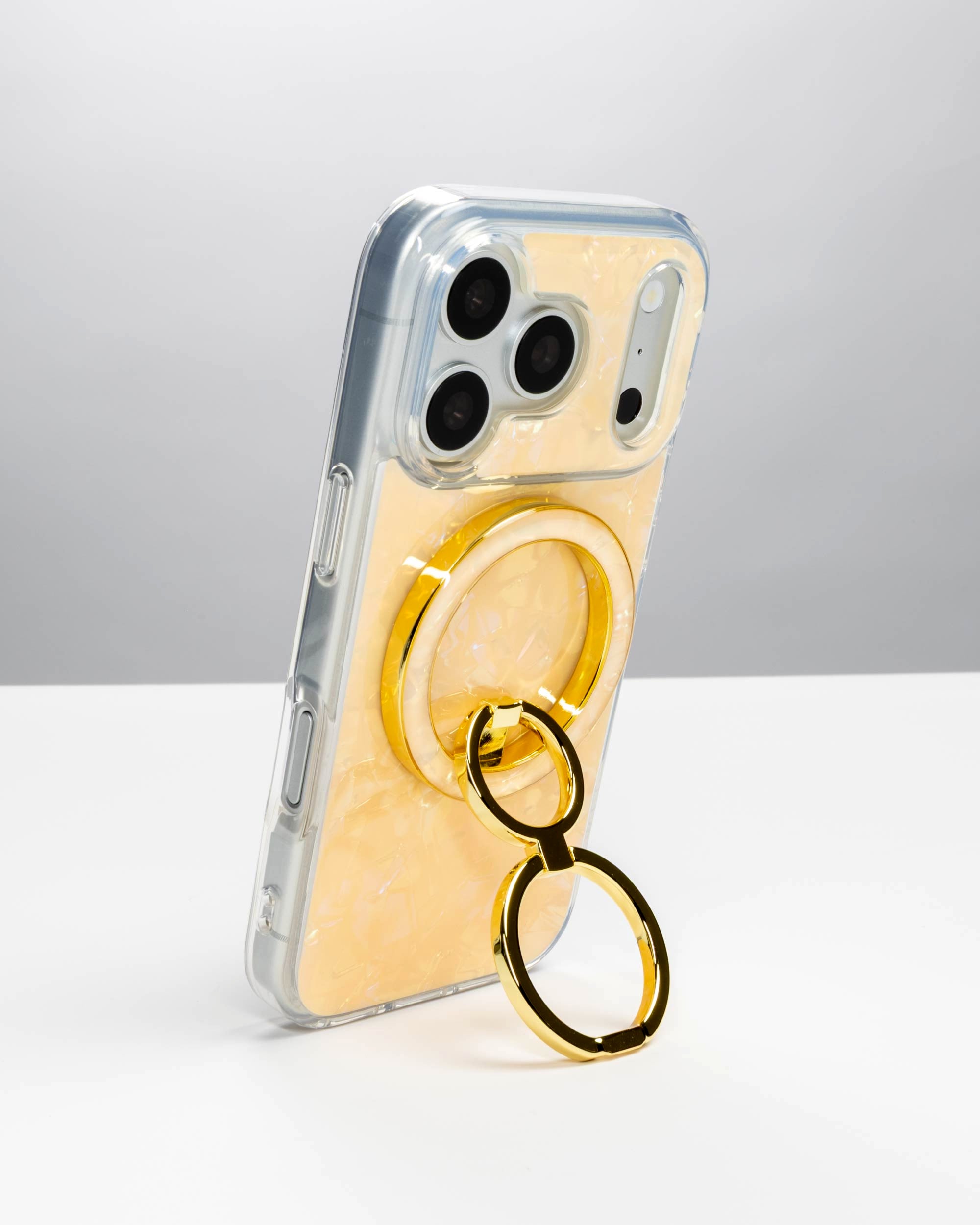 Apricot Shell Ring Stand, gold-tone, holding an iPhone upright as a stand