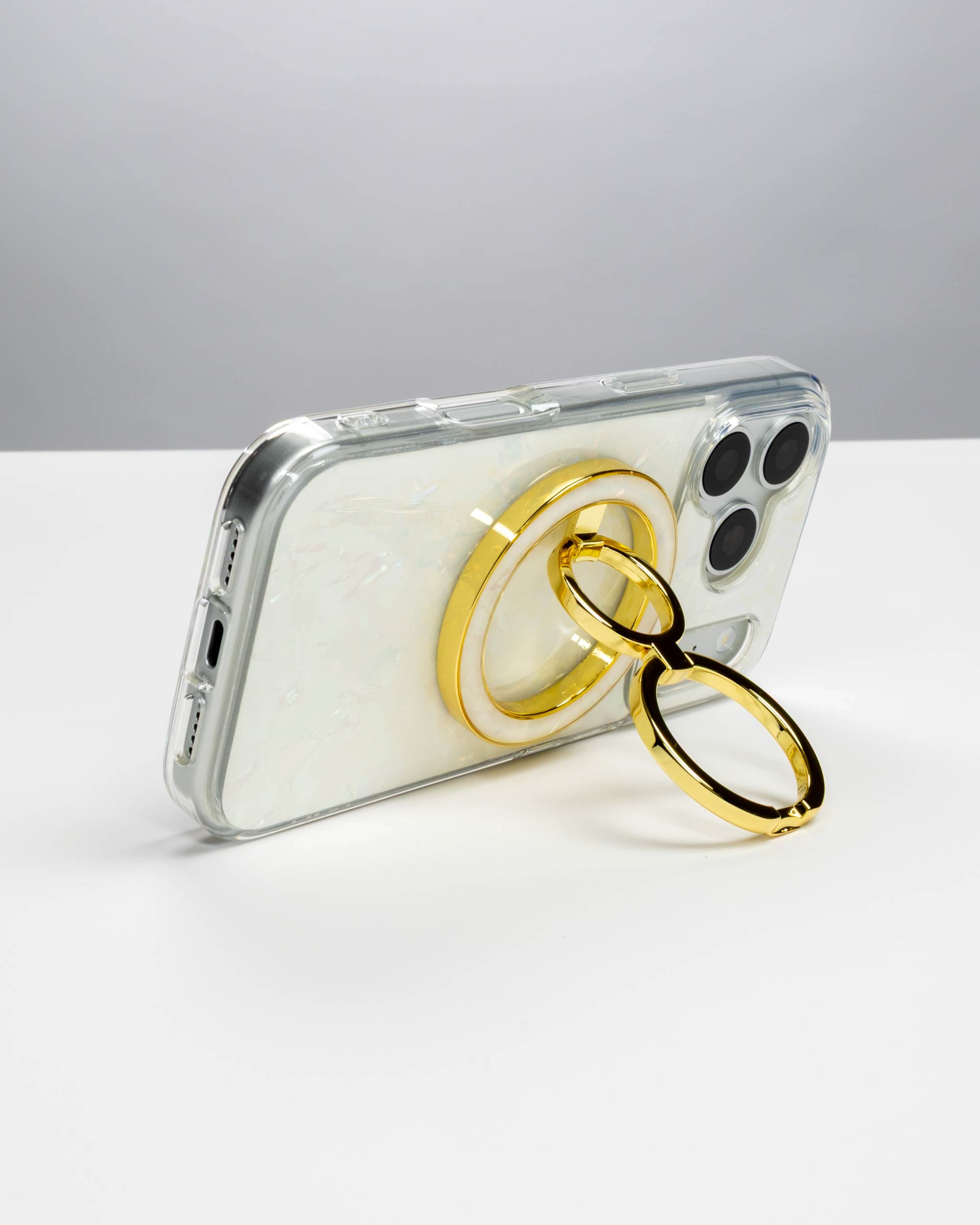 White Shell Ring Stand, gold-tone, holding an iPhone in landscape as a stand
