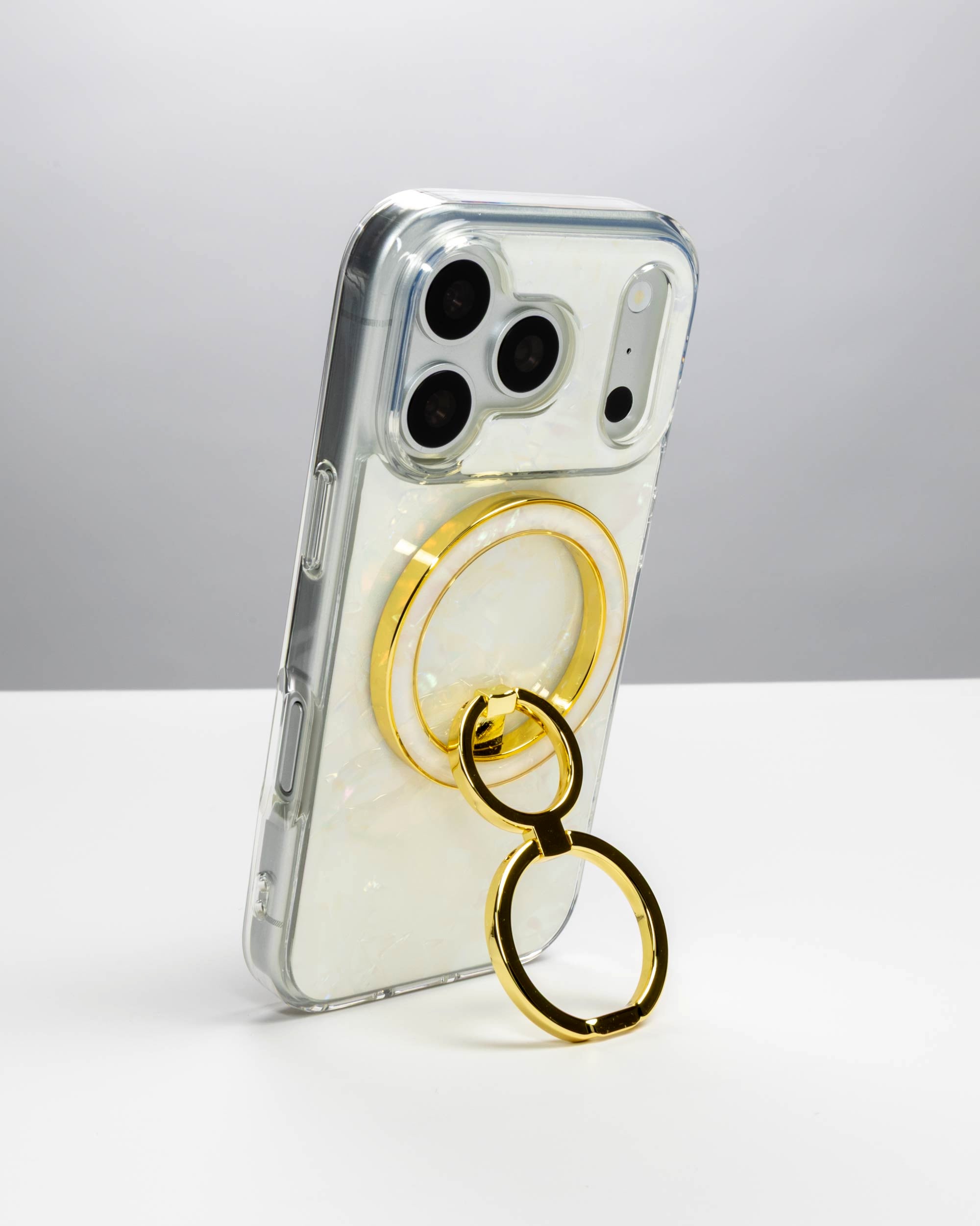 White Shell Ring Stand, gold-tone, holding an iPhone upright as a stand