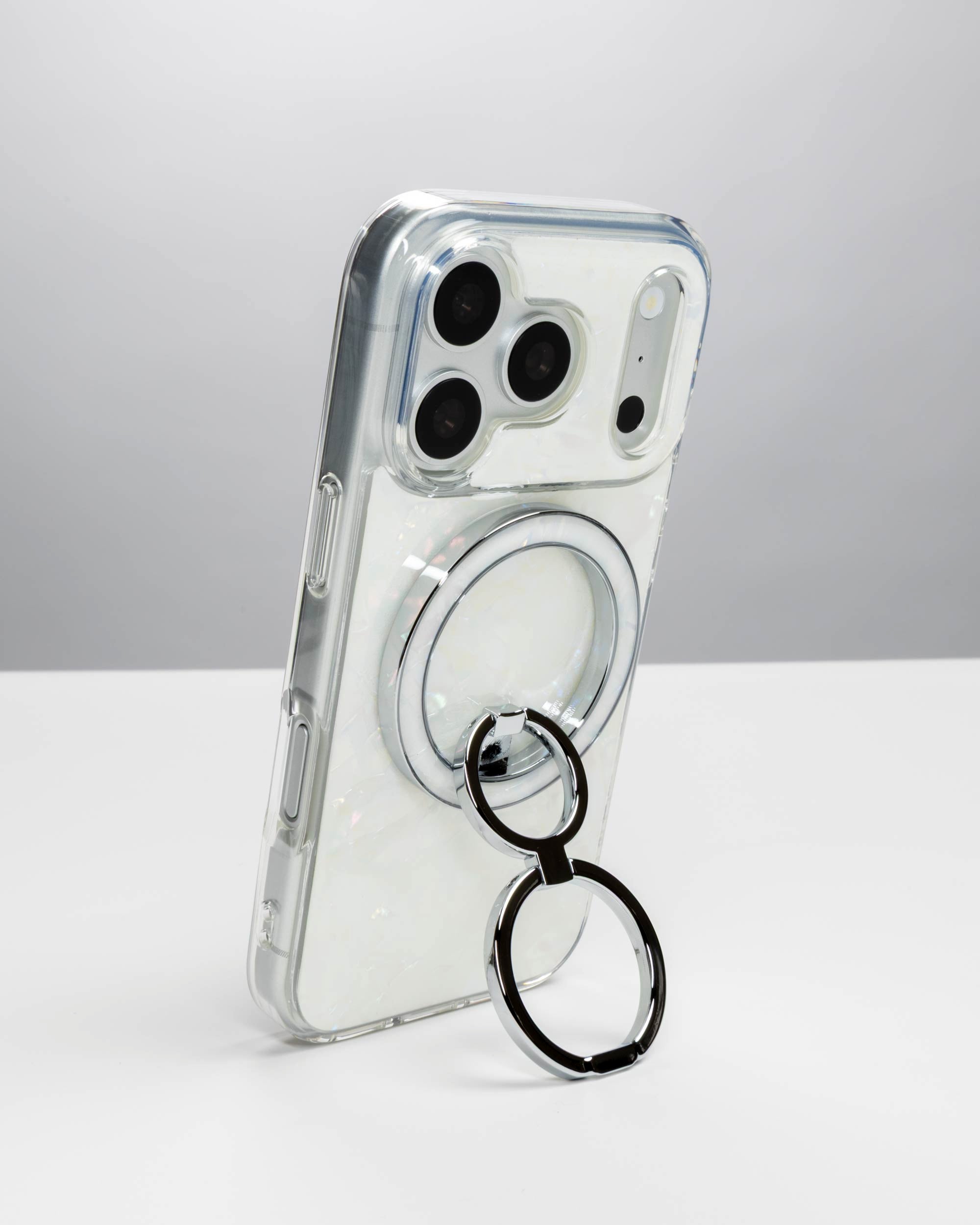 White Shell Ring Stand, silver-tone, holding an iPhone upright as a stand