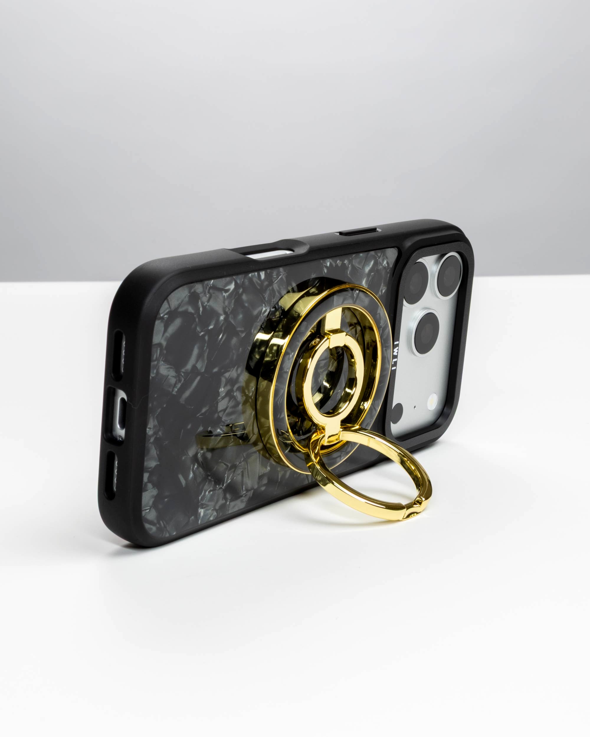 Black Shell Ring Stand, gold-tone, holding an iPhone in landscape as a stand