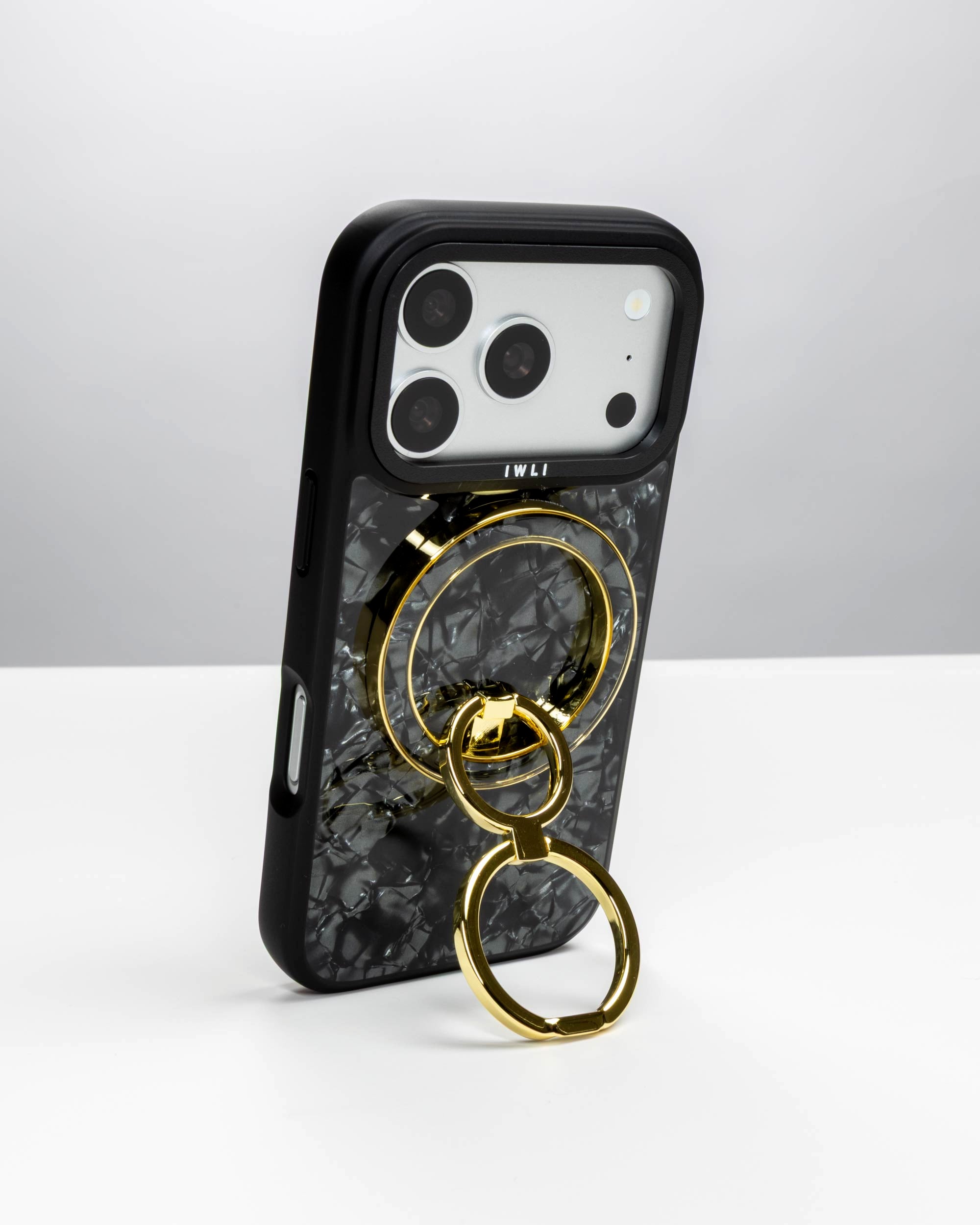 Black Shell Ring Stand, gold-tone, holding an iPhone upright as a stand
